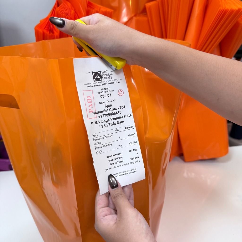 Tagging invoice to orange laundry bag